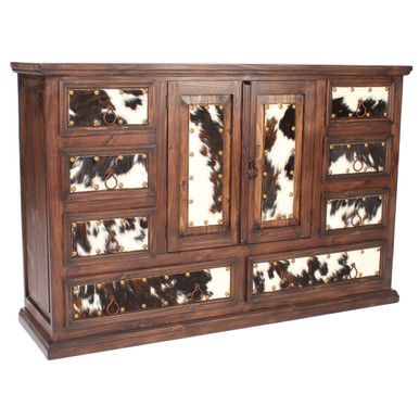 an old wooden sideboard with cow hides on the doors and drawers, made out of wood