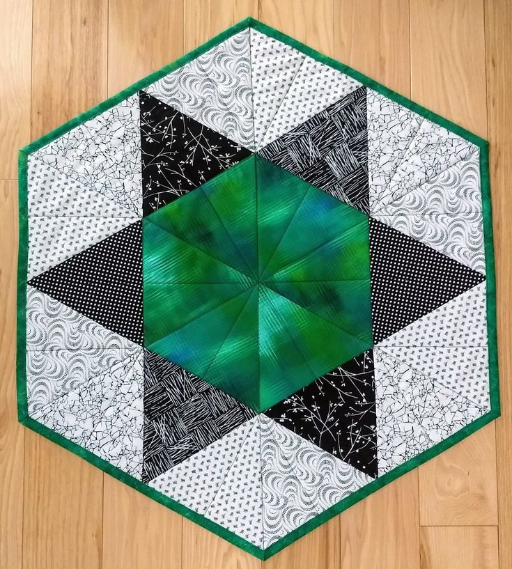 a green and black patchwork design on a wood floor