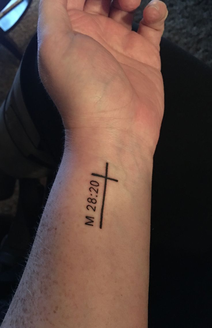 a person with a cross tattoo on their wrist