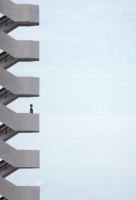 a person on a skateboard in front of a tall building with balconies