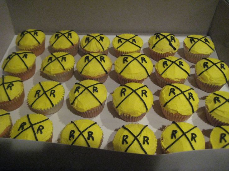 cupcakes with yellow frosting are arranged in a box and marked with the letters rr