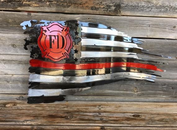 an american flag made out of scrap metal parts on a wooden planks wall with the word fire department written in red, white and blue