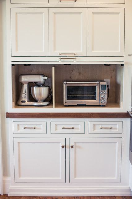 a kitchen with white cabinets and appliances on top of it's counter tops,