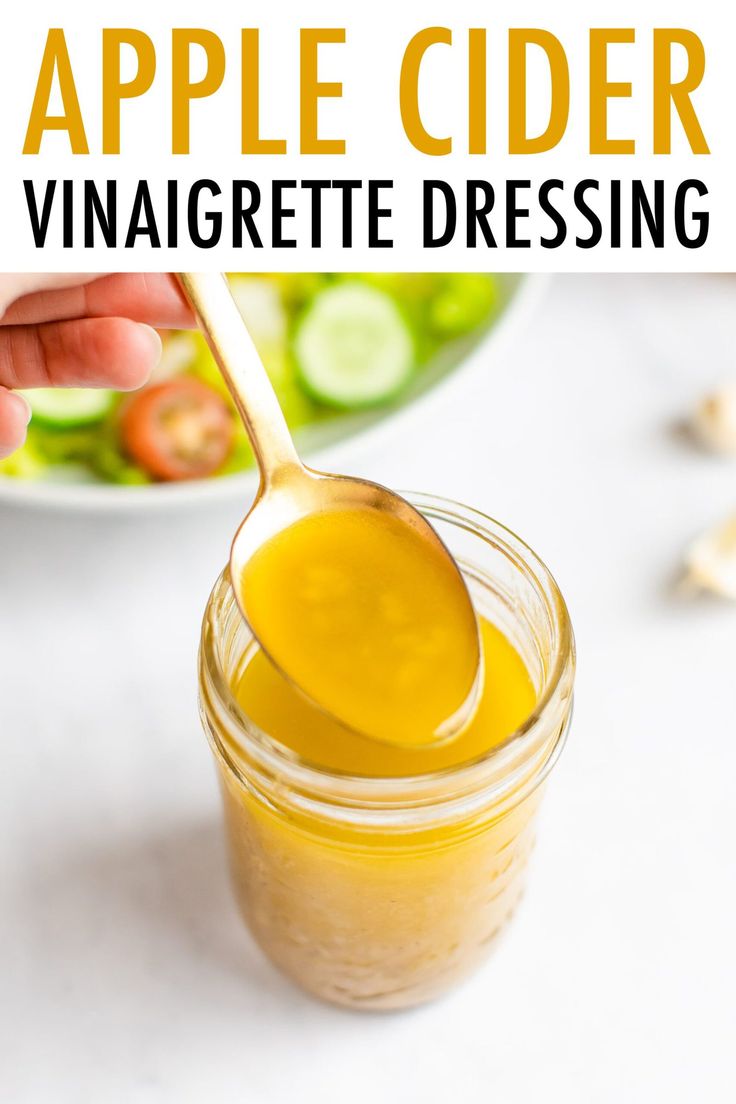 a spoon full of apple cider vinaigrete dressing on a white table