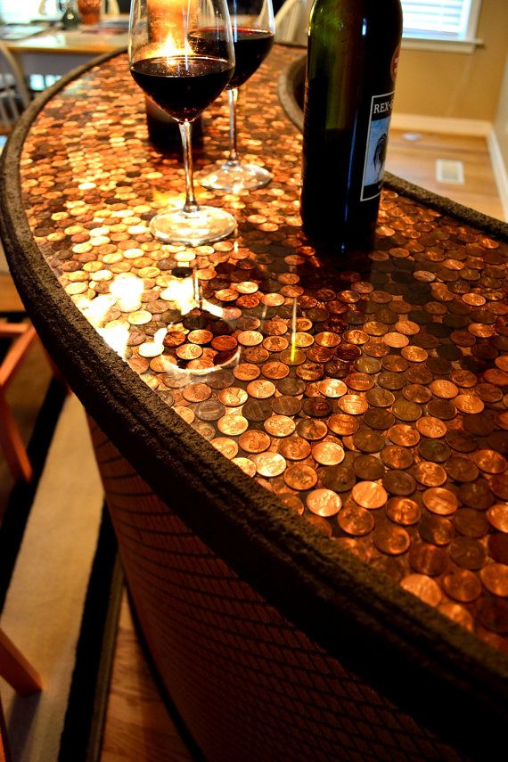 two wine glasses sitting on top of a counter covered in penn bills and one glass filled with red wine