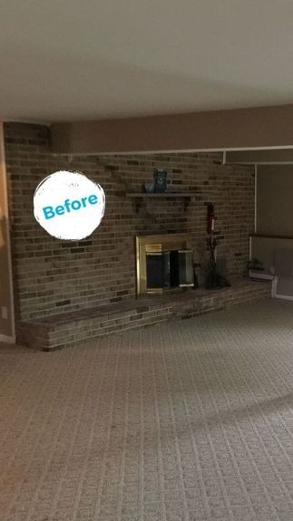 an empty living room with a fireplace and carpet