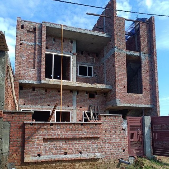 an unfinished brick building with windows and balconies on the second floor, under construction