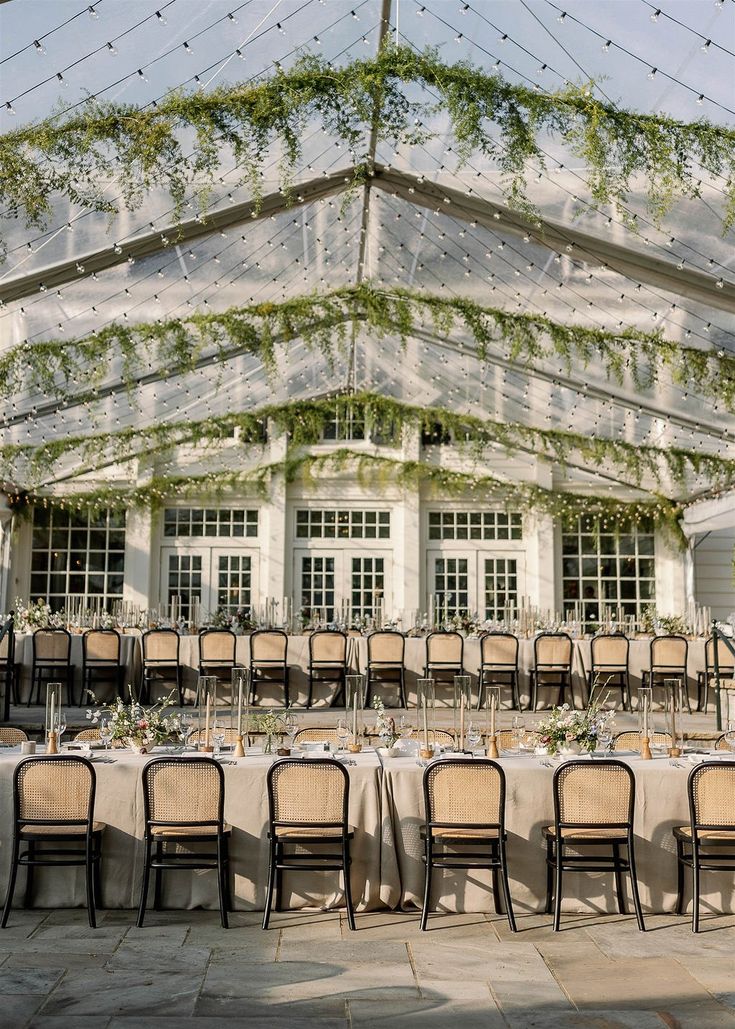 an outdoor venue with tables and chairs set up for a formal dinner under a tent