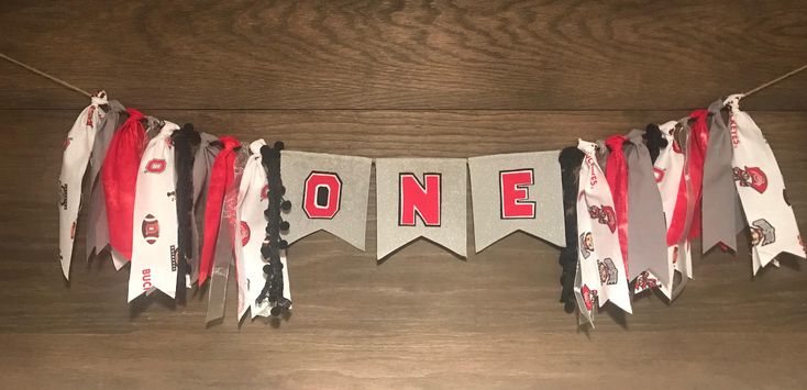 a banner with the word one on it hanging from a wooden table next to other decorations