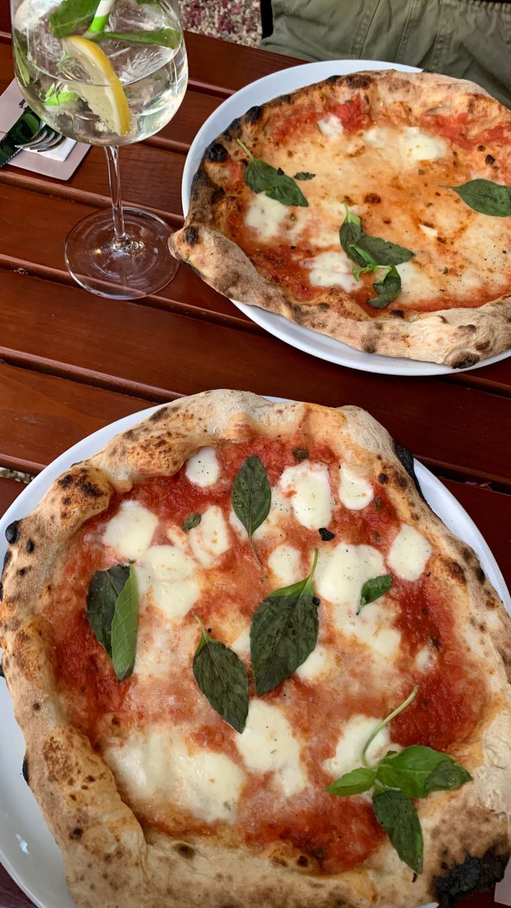 two pizzas sitting on top of white plates