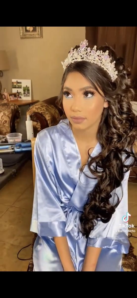 a woman with long hair wearing a tiara and sitting on a couch in a living room