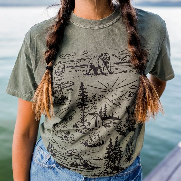 Our newest design for spring! We are so ready to explore the national forests this summer!! Unisex tee - model is wearing a medium Body Length 28 29 30 31 32 Chest Width (Laid Flat) 18 20 22 24 26 A Montana Scene Original Design. Printed in Montana. All designs are property of The Montana Scene. All rights reserved. All of The Montana Scene apparel is designed and printed locally in Montana. Come visit our storefront locations! Bigfork * Whitefish * Missoula * Kalispell * Bozeman Casual T-shirt For Outdoor Summer Activities, Casual Summer T-shirt For Outdoor, Summer Outdoor Cotton T-shirt, Casual T-shirt For Outdoor Spring Activities, Casual T-shirt For Spring Outdoor Activities, Casual T-shirt For Outdoor Spring Events, Green Crew Neck Top For Outdoor, Casual Spring Outdoor Tops, Green Graphic Tee For Outdoor