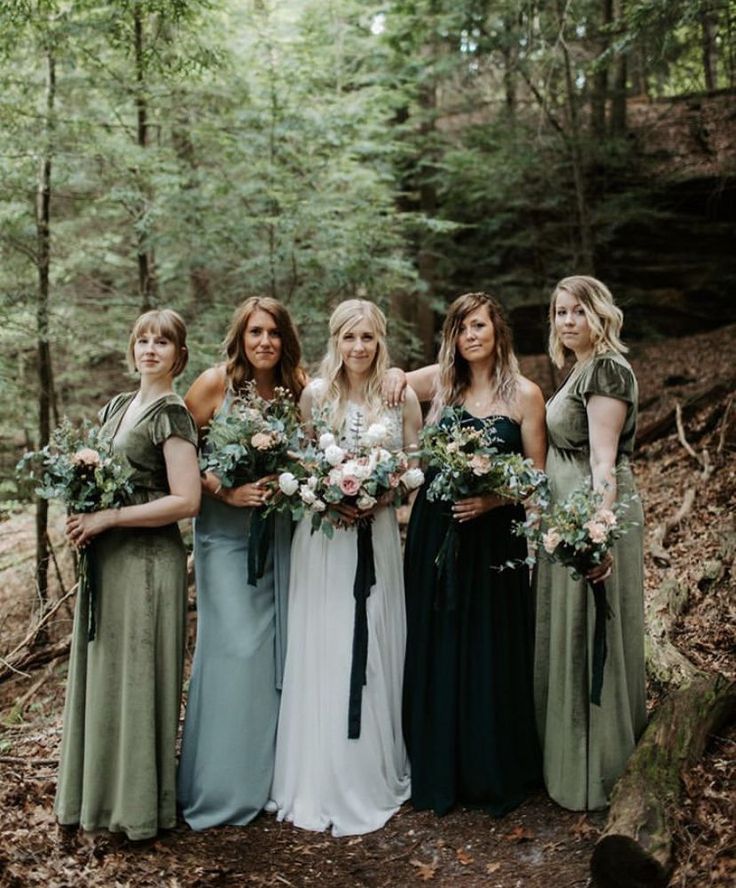 a group of women standing next to each other in the woods