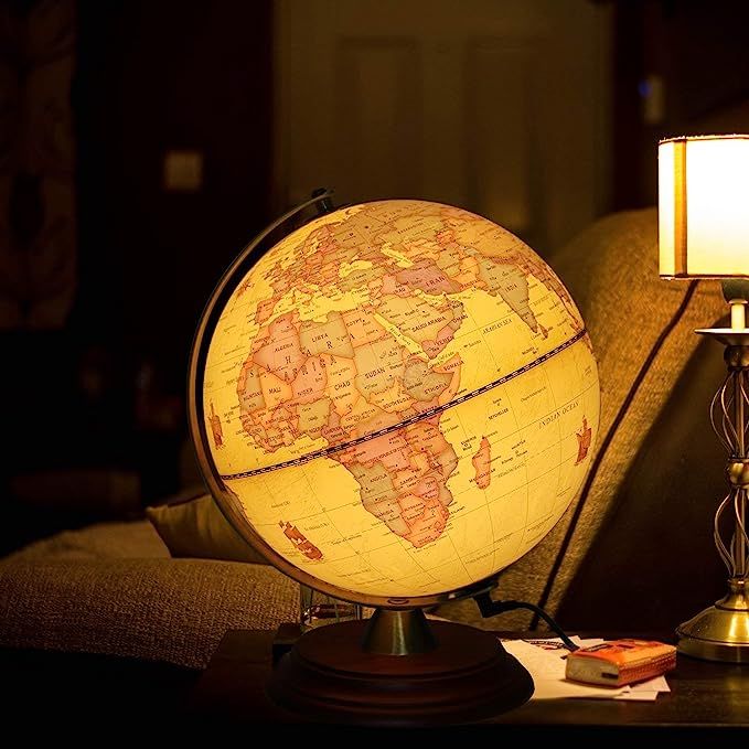 a globe sitting on top of a table next to a lamp