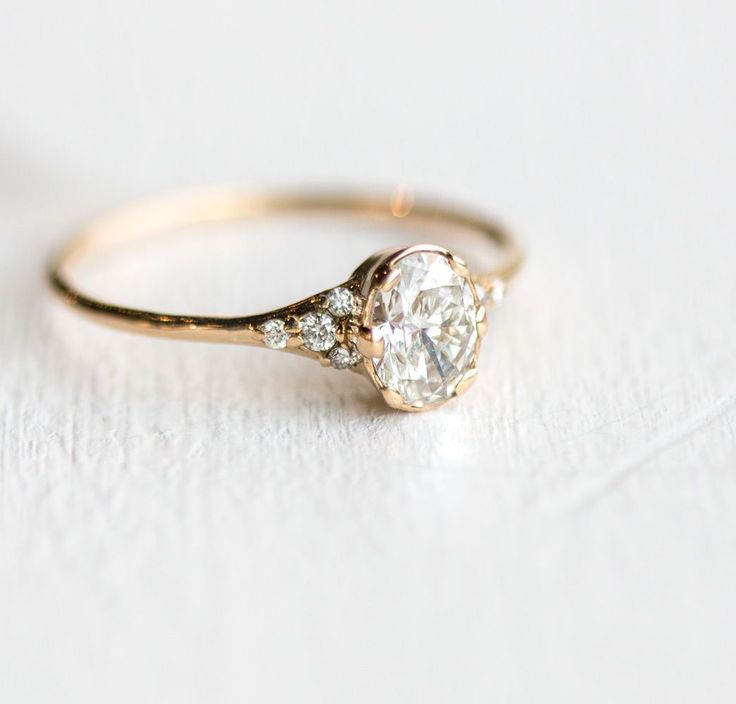 a close up of a diamond ring on a white surface