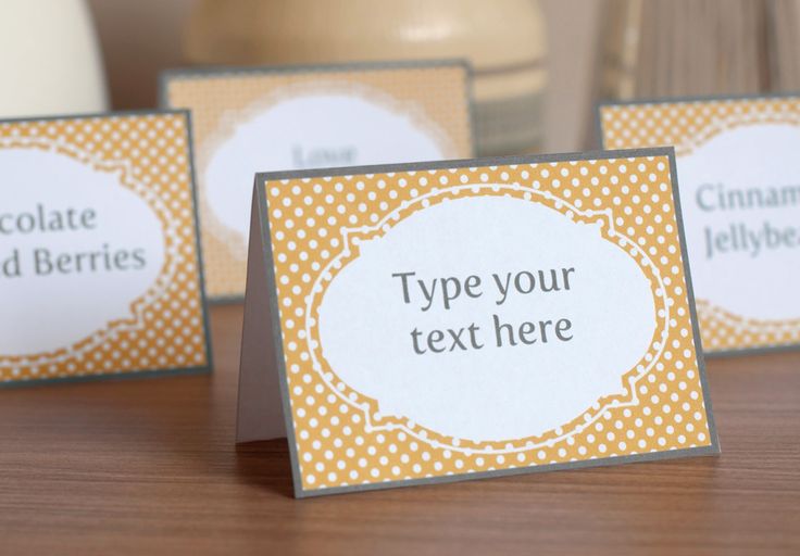 three place cards sitting on top of a wooden table