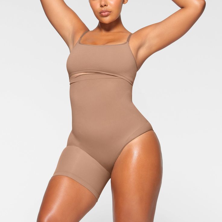 A perfect solution for outfits with an exposed left leg, this mid-waist and ultra-compressive short supports the tummy, waist, and thighs while enhancing and lifting your butt. Features an underband with interior silicone to prevent rolling and large round butt pockets. Fits true to size. | SKIMS Solution Short Left Leg Exposed (Bodysuit) | Medium Neutral | Seamless Sculpt Deep Plunge Bodysuit, Thigh Sculpting, Maternity Tights, Vintage Cami, Plunge Bodysuit, Belly Support, Mid Thigh Shorts, High Neck Bodysuit, Backless Bodysuit