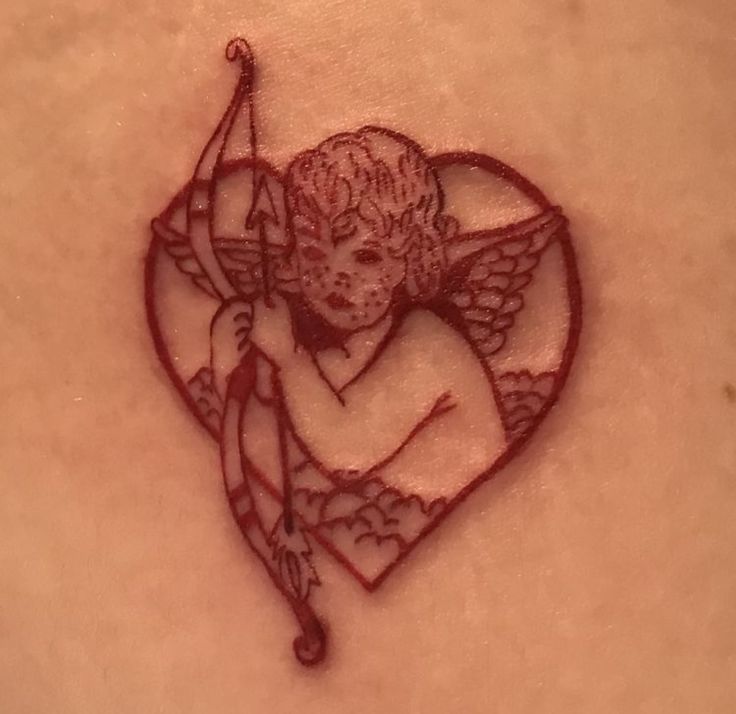 a tattoo with an image of a cupid holding a bow and arrow in the shape of a heart