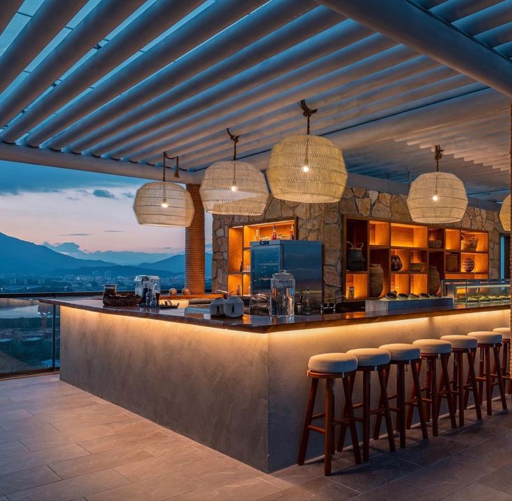 an outdoor bar with stools and lights