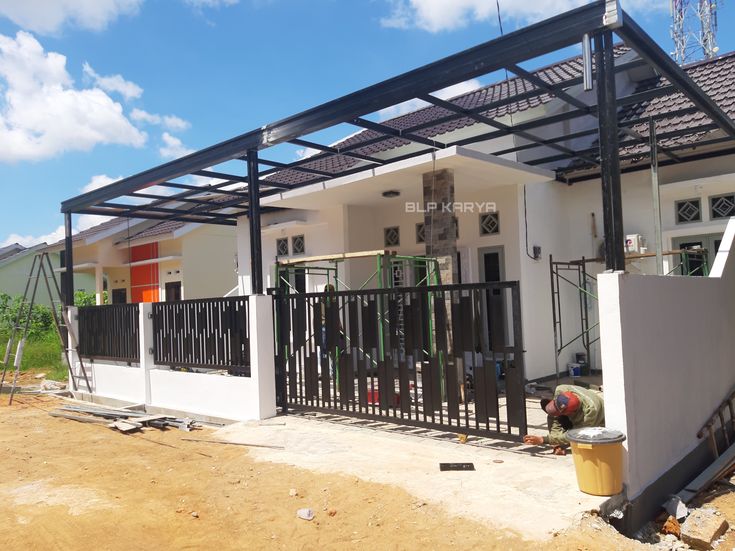 a man standing in front of a house under construction