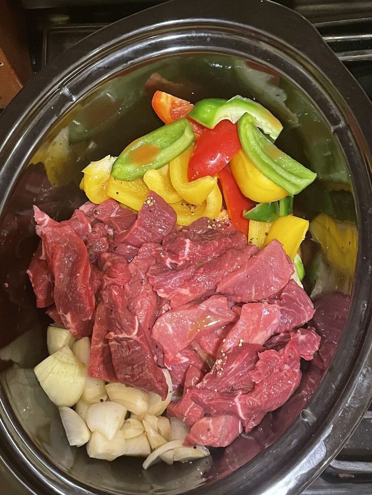 meat and vegetables in a bowl on the stove