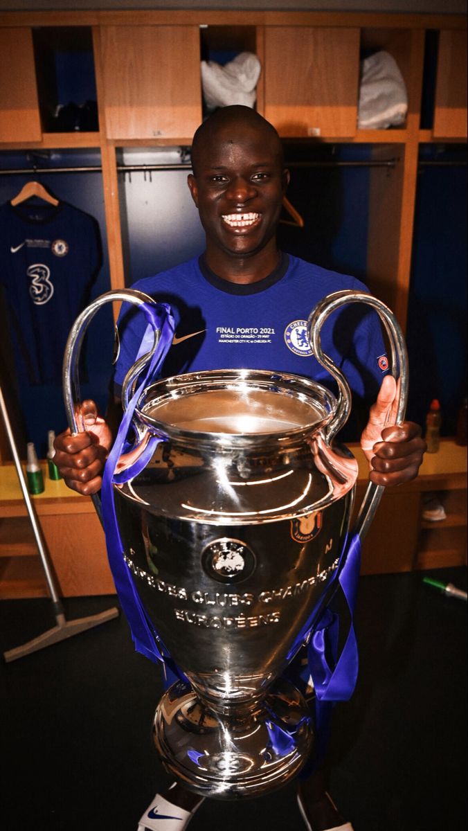 a man holding up a soccer trophy in his hands