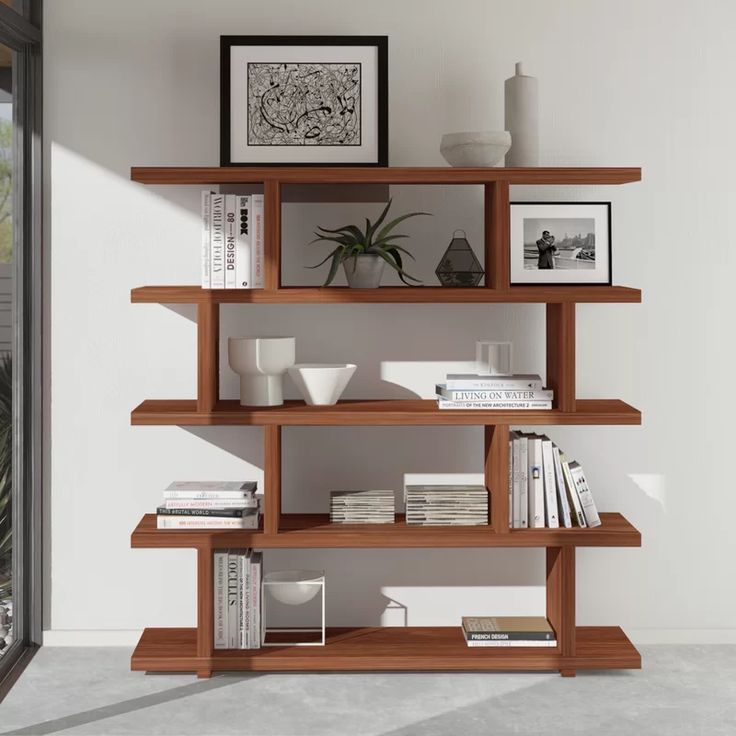 a bookshelf filled with lots of books next to a window in a room