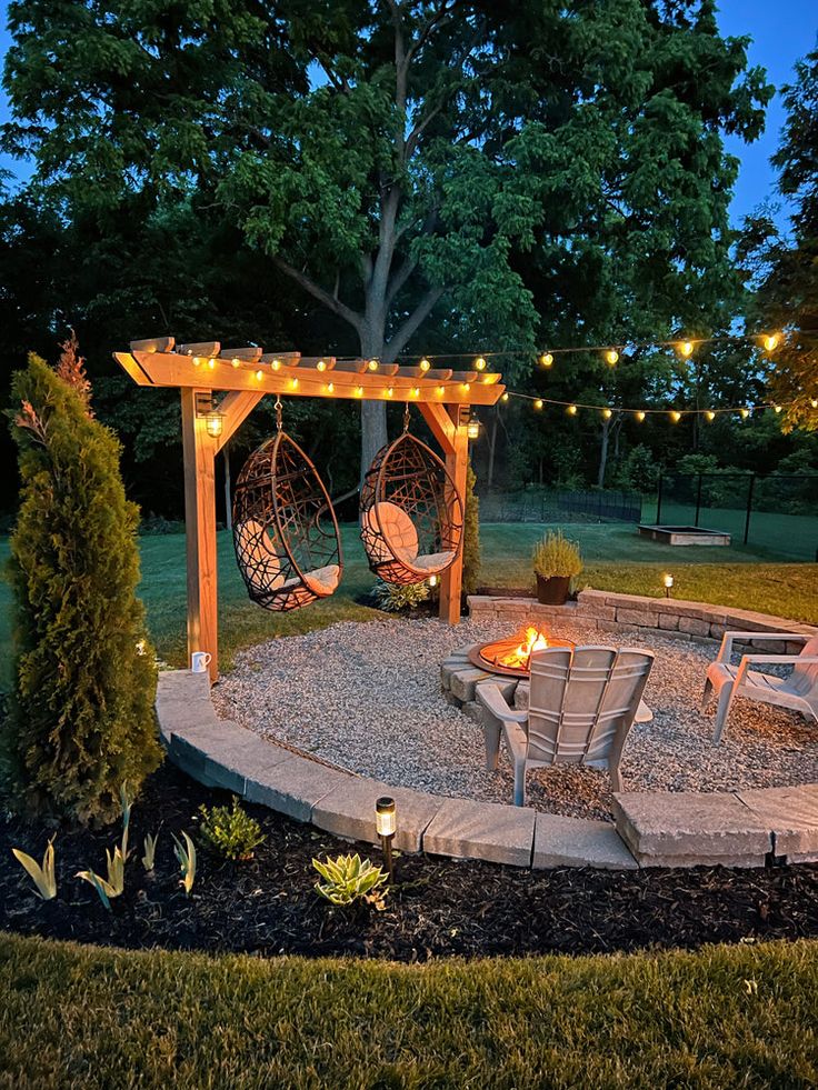 an outdoor patio with lights strung around the seating area and fire pit in the middle