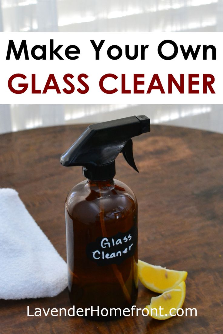 a bottle of glass cleaner sitting on top of a wooden table next to a white towel