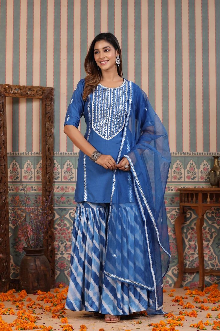 Be a vision in our Blue Tie And Dye Sharara Suit Set. Crafted in cooling blue hues of muslin featuring a unique tie and dye design, this lovely suit set is the perfect choice for summer weddings and festive occasions. The set is complete with an airy organza dupatta to add a touch of harmony to the ensemble. No. of pieces - 3 piece set. Color - Blue. Fabric - Muslin. Washing Instructions - Dry Clean. Blue Fitted Straight Kurta Pant Set, Blue Fitted Pant Set With Straight Kurta, Blue Cotton Palazzo Set With Dupatta, Festive Blue Straight Kurta Pant Set, Festive Blue Pant Set With Straight Kurta, Blue Cotton Pant Set With Straight Kurta, Blue Palazzo Set With Dupatta For Summer, Summer Blue Palazzo Set With Dupatta, Festive Blue Cotton Pant Set