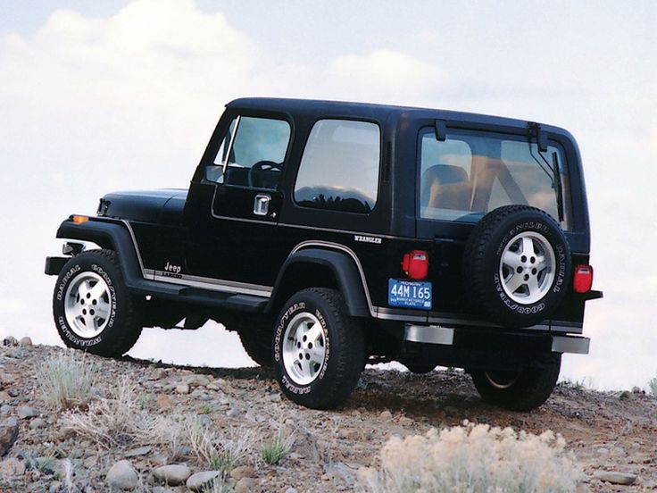 a black jeep parked on top of a rocky hill