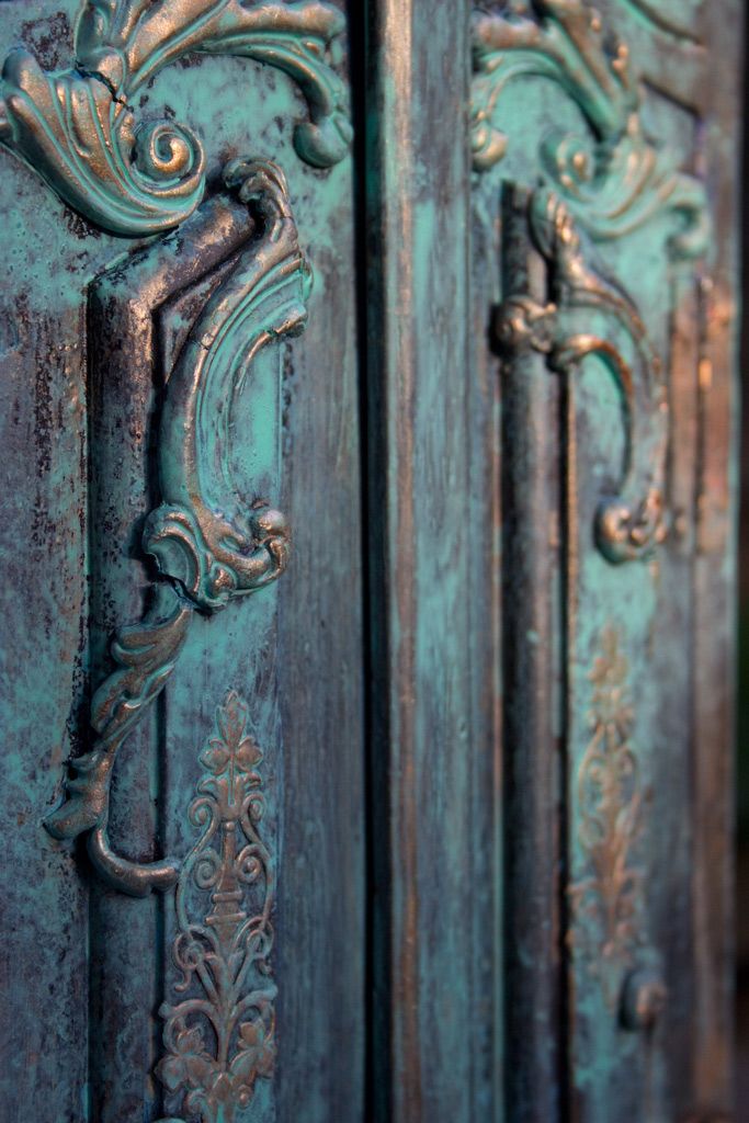 an ornately painted wooden door with metal handles