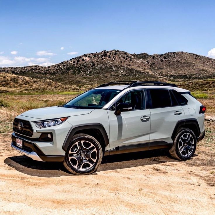 the new toyota rav is parked on a dirt road