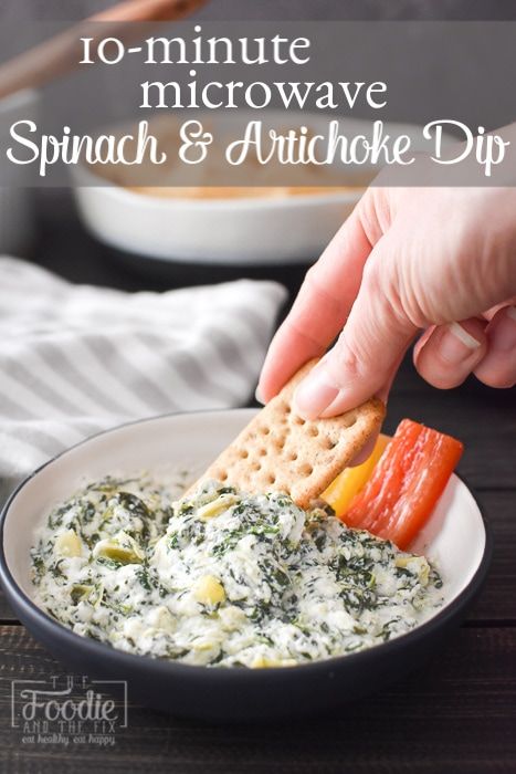 spinach and artichoke dip in a bowl with crackers