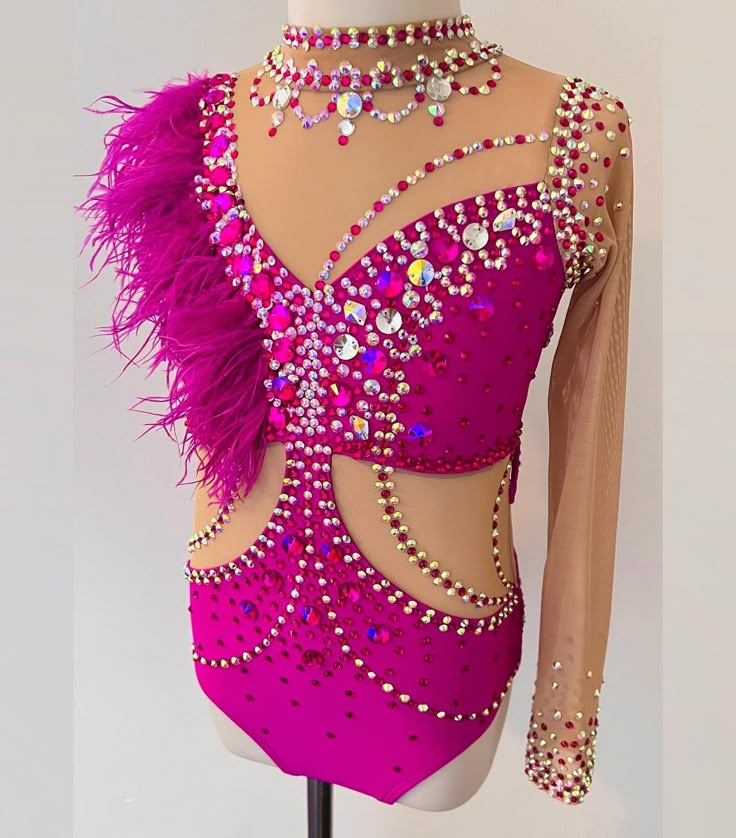 a pink leotard with purple feathers and jewels on the neckline is shown in front of a mannequin