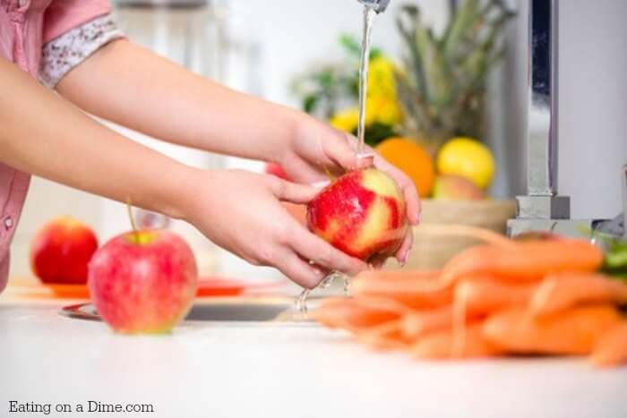 a woman is peeling an apple in the kitchen