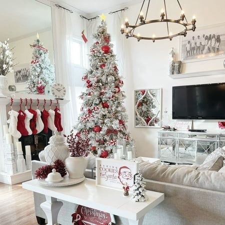 a living room decorated for christmas with white and red decorations