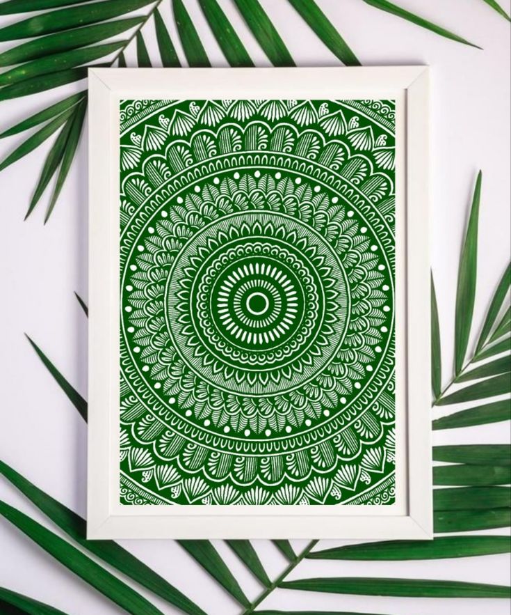 a green and white art print on a wall next to some palm leafy branches