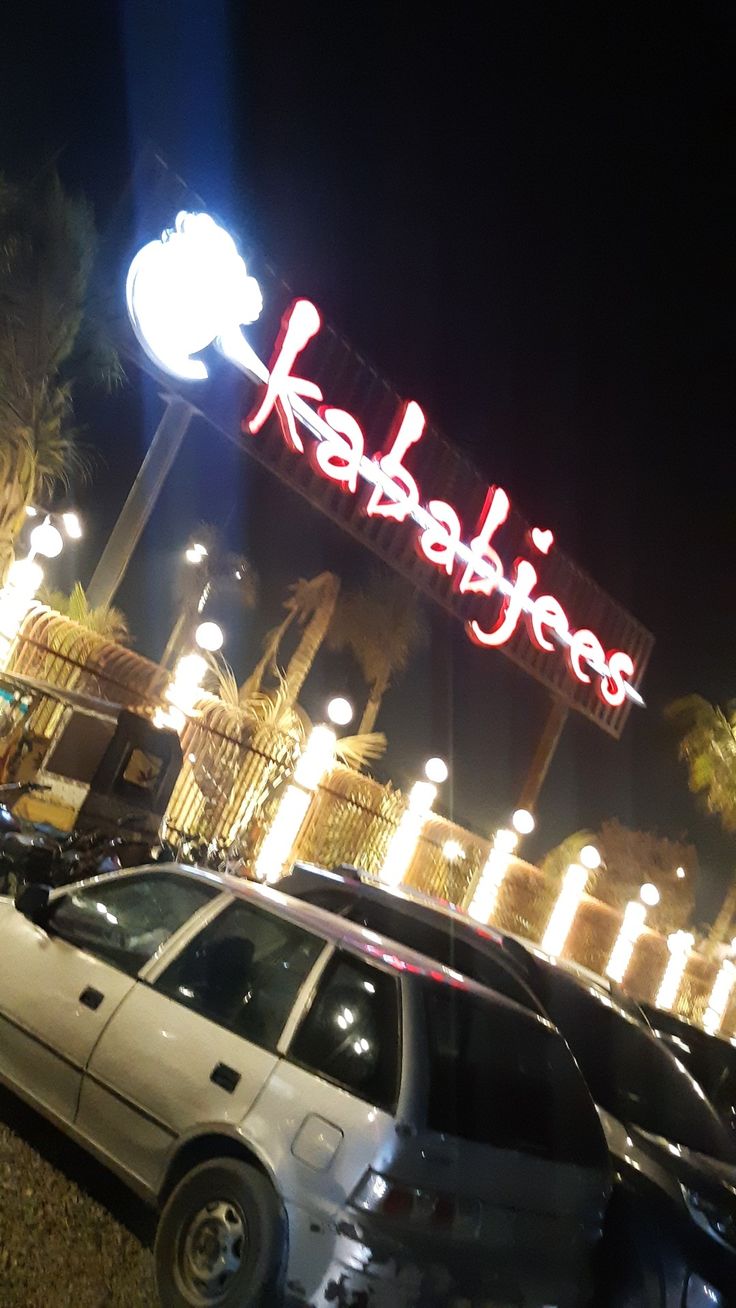 a car parked in front of a building with a neon sign above it that says kababes