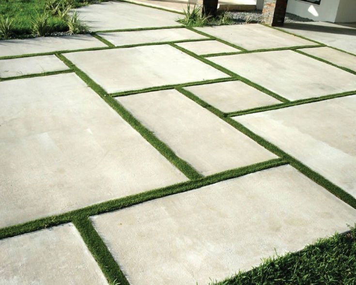 an outdoor patio with grass and stepping stones