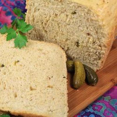 a loaf of bread sitting on top of a cutting board next to a pickle