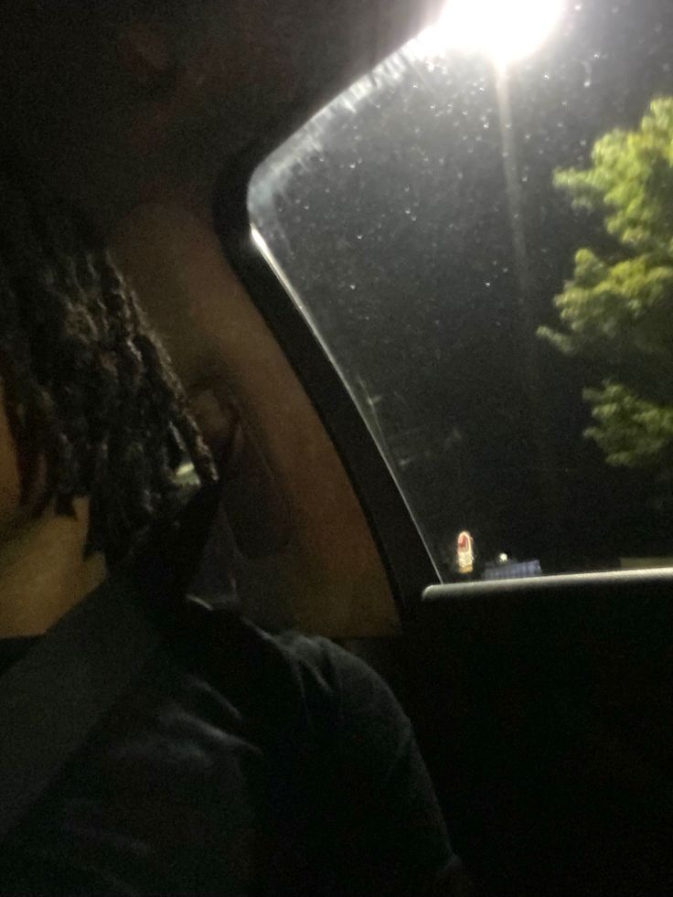 a man sitting in the back seat of a car at night