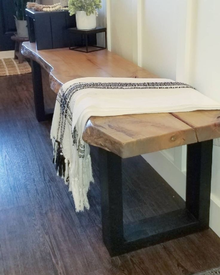 a wooden bench with a white blanket on it