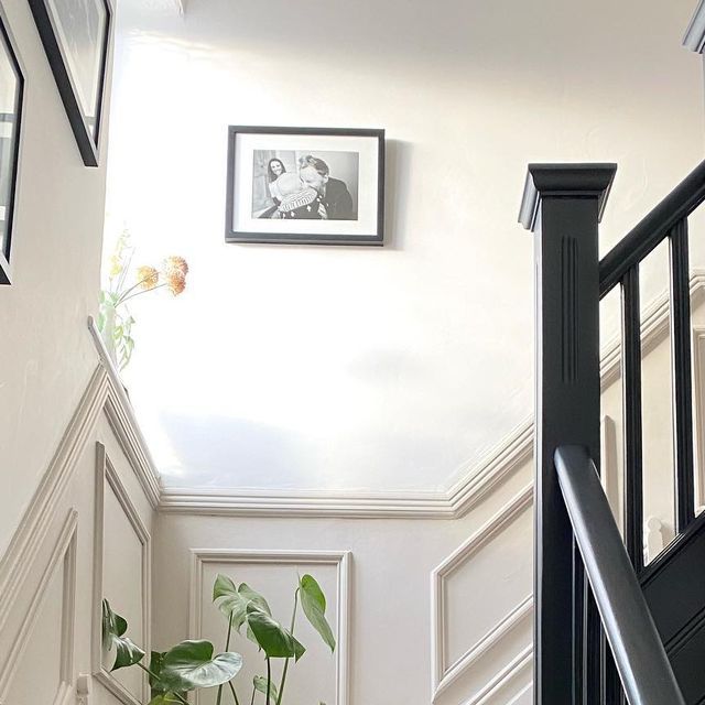 a staircase with pictures on the wall and potted plants