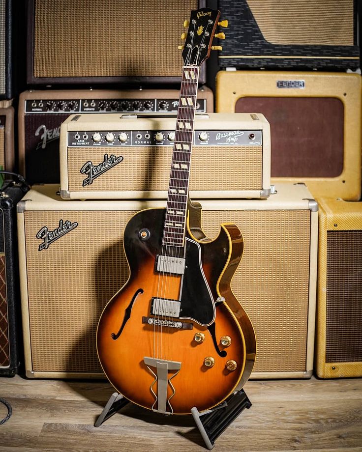 an electric guitar sitting on top of a wooden floor next to amps and guitars