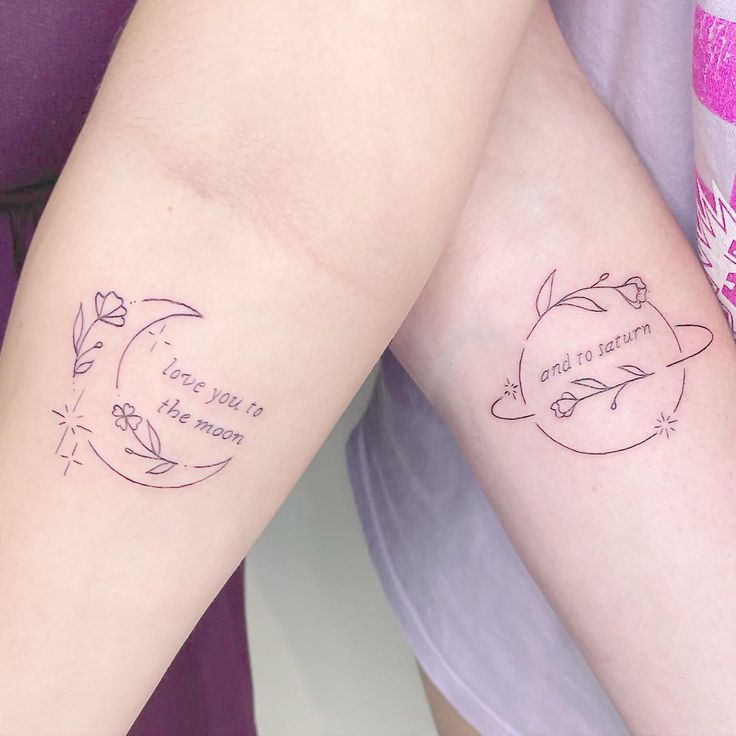 two people with matching tattoos on their arms, one is holding the other's arm