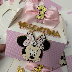 there is a box that has some minnie mouse stickers on it and pink bows