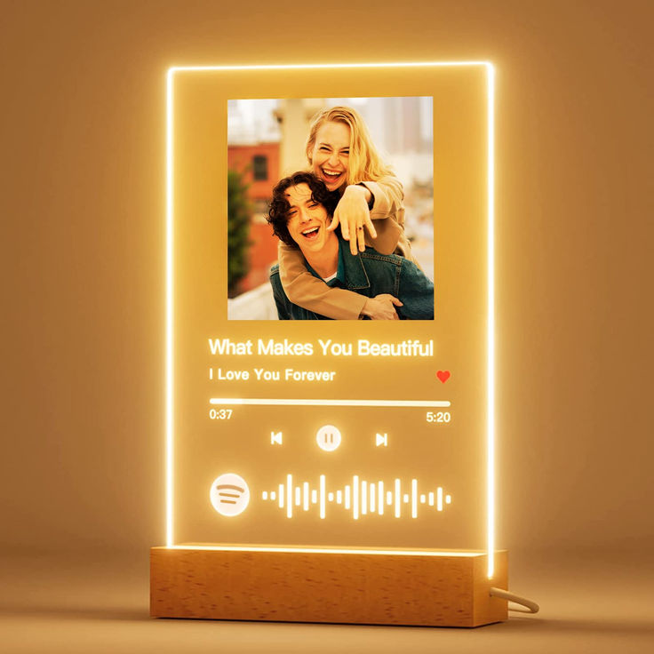 an illuminated photo frame with the words what makes you beautiful on it and sound waves