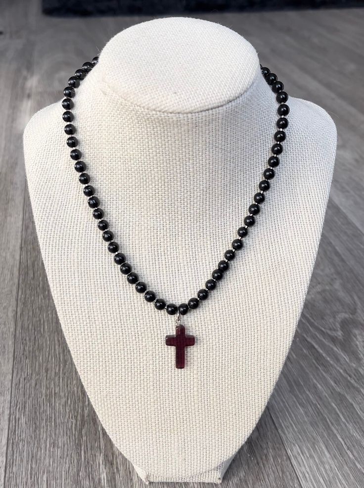 This gothic inspired piece was handmade with glass beads, a simulated amethyst glass cross charm, as well as stainless steel findings. It's super wearable and simple and made to fit everyone! It sits at 16 inches and is adjustable to 19 inches. Message me with any questions or requests! Beaded Spiritual Cross Pendant Necklace, Spiritual Black Cross Beaded Necklace, Adjustable Cross Necklace With Black Beads, Adjustable Black Beads Cross Necklace, Adjustable Cross Necklace With 8mm Beads, Handmade Black Crucifix Necklace, Handmade Black Cross Necklace, Handmade Adjustable Black Cross Necklace, Black Beaded Cross Necklaces As Gift