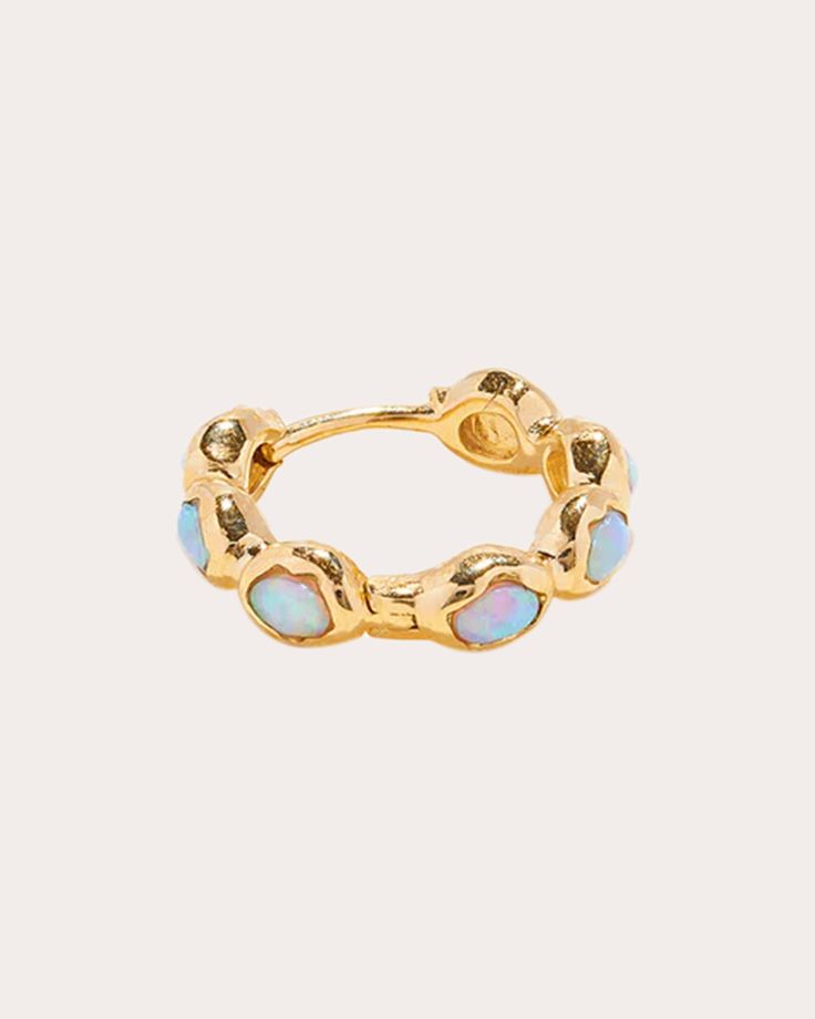 Crafted from solid 14-karat gold, this huggie-sized hoop is decorated with synthetic opal stones for a hint of iridescent appeal. Sold as a single, this petite earring is ideal for helix, conch and other one-off piercings. Sold as a single earring 14k yellow gold and synthetic opal Polish with soft cloth Made in China Measurements Inner diameter: 11mm Sustainability Metrics: Circular Economy: product is intentionally designed with 50% of actively cycled materials Conflict-Free: 100% of products Petite Earrings, Synthetic Opal, Circular Economy, Single Earring, Conch, Huggies Earrings, Helix, Piercings, Sustainability